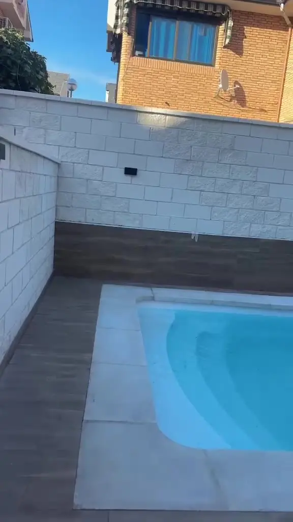 Terraza con piscina y suelo porcelánico imitación madera